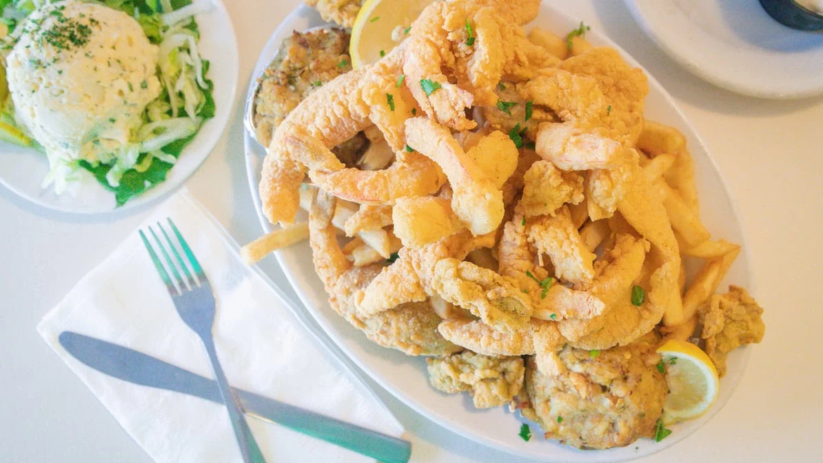 Deanie's Seafood Platter - A generous serving of golden-fried shrimp, oysters, and catfish.